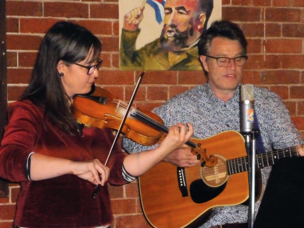 Sally playing violin and Andrew playing guitar